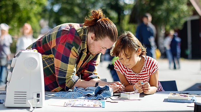 En man sitter och ler. På bilden syns texten "Väsby hållbarhetskalender 2025".