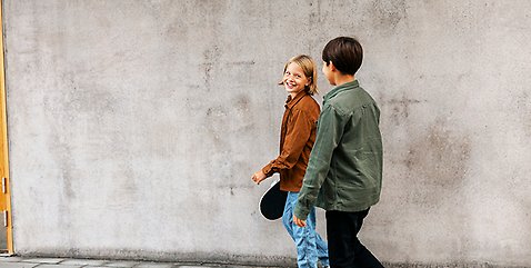 Två killar som går och pratar med varandra. 