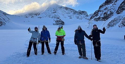 Bild på fyra lärare som gjorde resan. De står utomhus med vinterlandskap och berg bakom. 