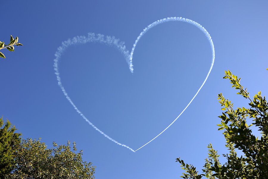 Hjärta av moln eller flygplan på himlen.